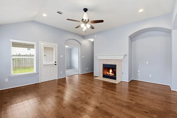 an empty room with a fireplace and wooden floor