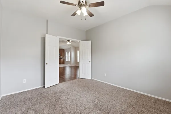 a view of a hallway with a chandelier fan and windows