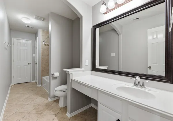 a bathroom with a sink and mirror with toilet