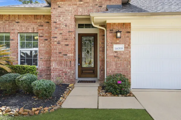 a front view of a brick house with a yard