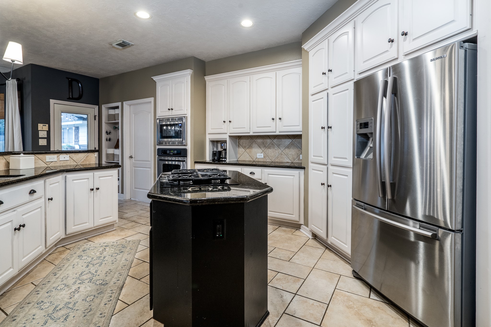 10411 Harnwell Crossing Drive Spring, TX 77379 - Photo 14 of 50 a kitchen with stainless steel appliances granite countertop a refrigerator a sink and white cabinets