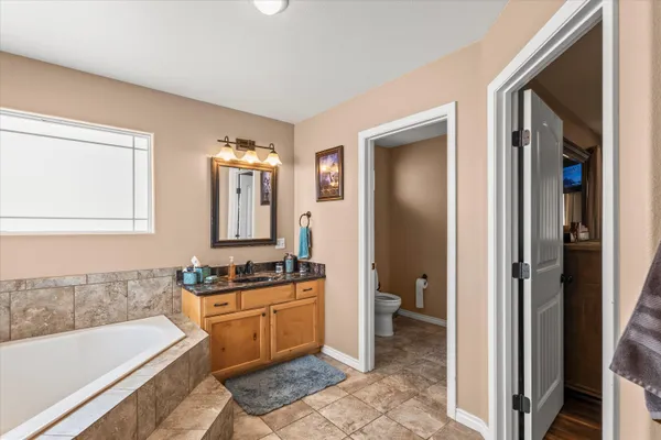 a bathroom with a tub sink and mirror