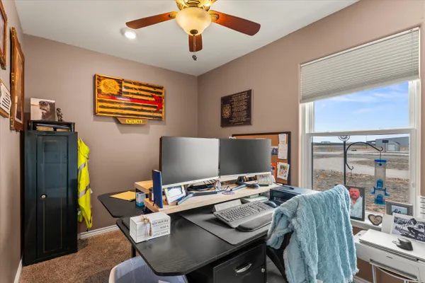 a view of a workspace with furniture and a window