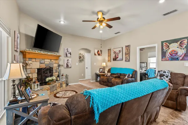 a living room with furniture a flat screen tv and kitchen view