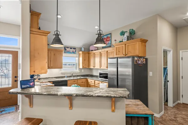 a kitchen with stainless steel appliances granite countertop a sink a counter space and cabinets