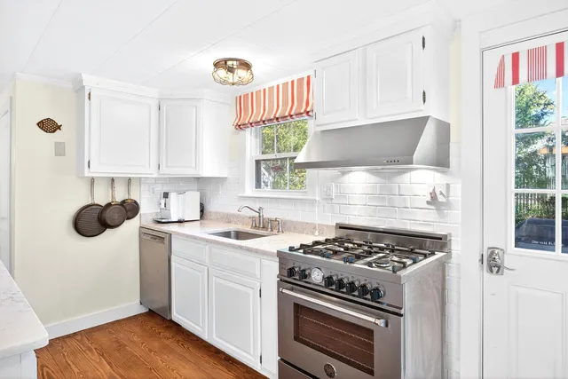 a kitchen with a stove a sink and a window
