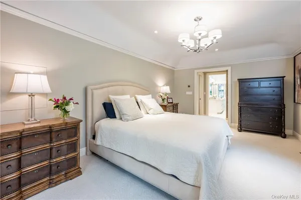 a spacious bedroom with a bed and a chandelier