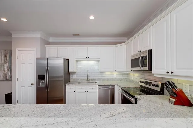 a large kitchen with kitchen island a sink stainless steel appliances and cabinets