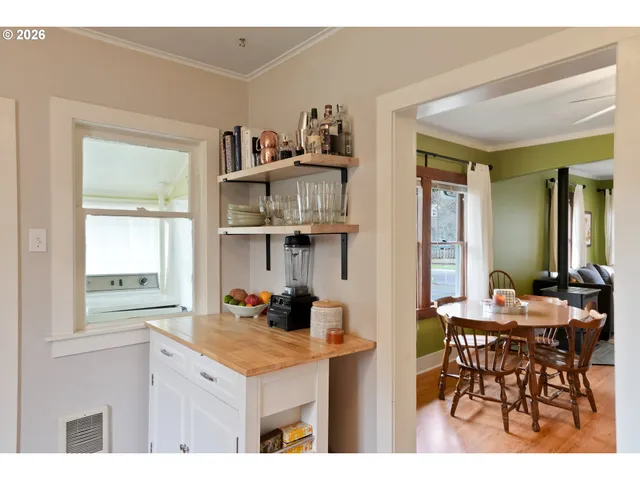 a kitchen with stainless steel appliances granite countertop a table and chairs in it