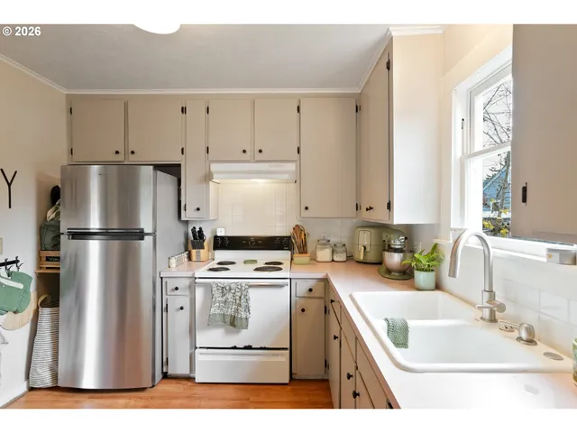 a kitchen with a refrigerator sink and white cabinets