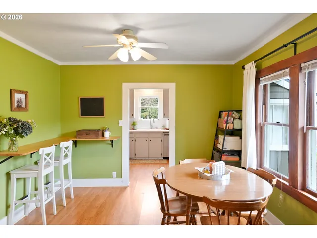 a dining room with wooden floor a chandelier a wooden table and chairs