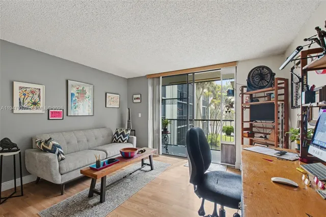 a living room with furniture a rug and a floor to ceiling window