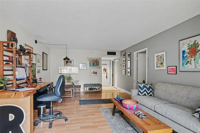 a living room with furniture a flat screen tv and a table
