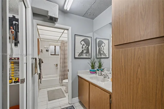 a bathroom with a granite countertop sink a mirror and a shower