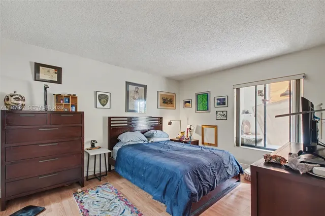 a bedroom with a bed a dresser and a large mirror