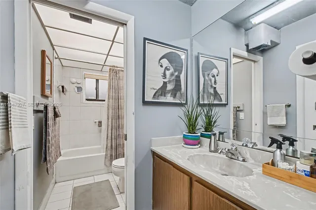 a bathroom with a granite countertop sink a mirror and shower