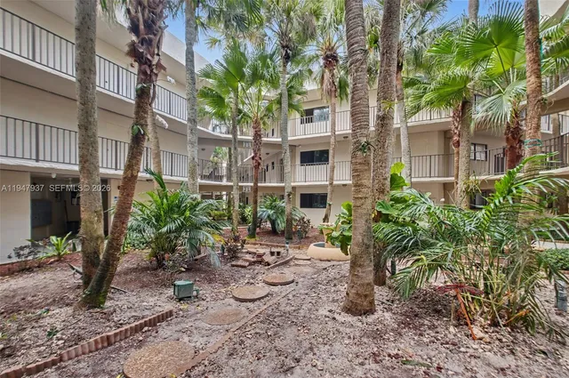a view of an house with backyard and trees