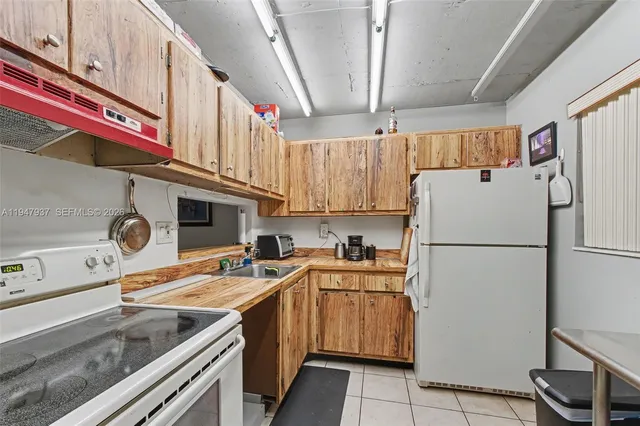 a kitchen with a sink a refrigerator and cabinets