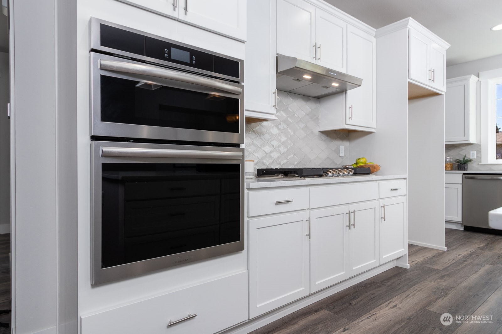 859 Field Avenue Northeast Renton, WA 98059 - Photo 7 of 27 a kitchen with stainless steel appliances white cabinets and a stove a oven with wooden floors