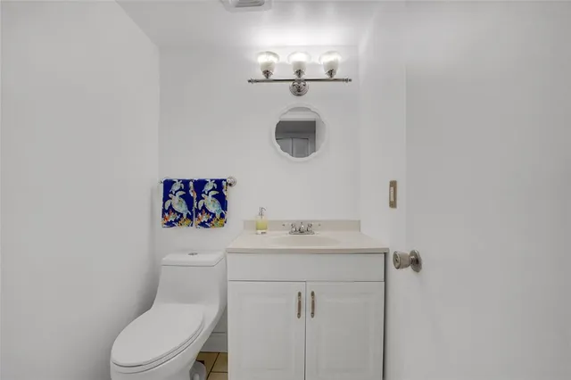 a bathroom with a sink vanity mirror and toilet