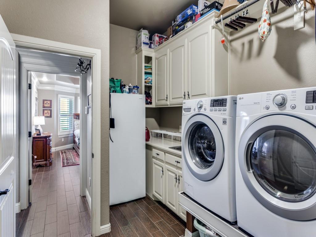 259 Hidden Creek Road Cresson, TX 76035 - Photo 22 of 28 Laundry room with wood finish floors, washing machine and dryer, cabinet space, crown molding, and a textured wall
