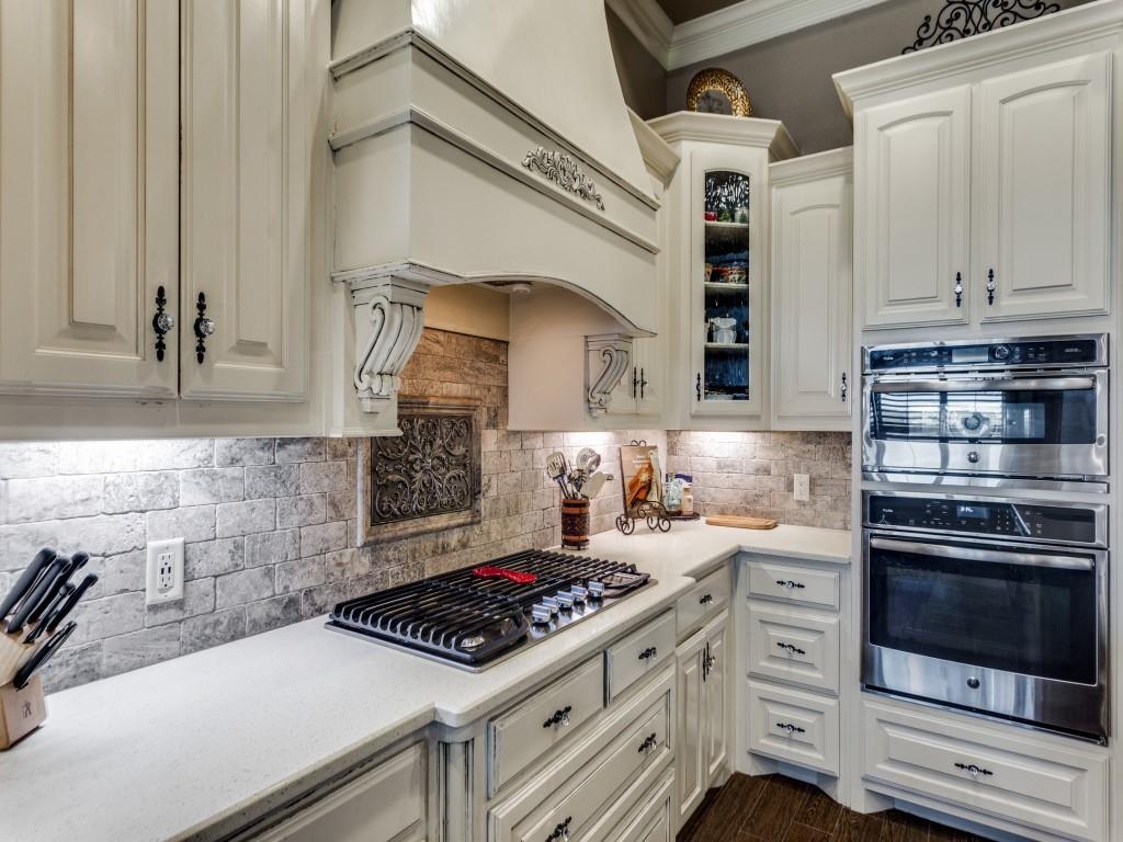 259 Hidden Creek Road Cresson, TX 76035 - Photo 9 of 28 Kitchen featuring stainless steel appliances, glass fronted cabinets, light stone countertops, white cabinets, and ornamental molding