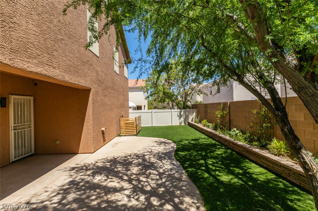 8909 Houston Ridge Avenue Las Vegas, NV 89178 - Photo 40 of 45 A private yard with an inviting concrete patio and lush green space, perfect for outdoor enjoyment.