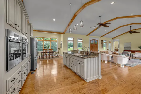 a open kitchen with stainless steel appliances granite countertop a stove and a wooden floors