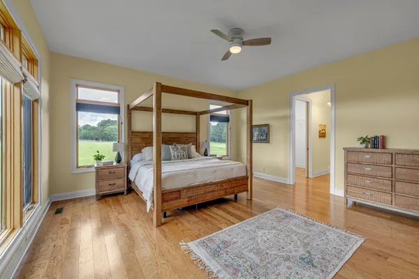 a bed sitting in a spacious bedroom next to a window