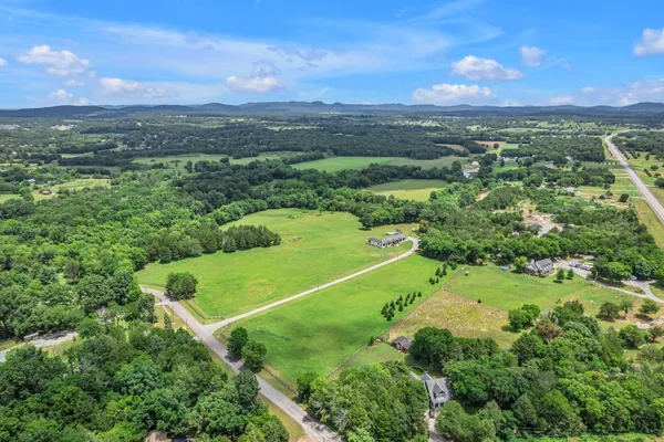 a front view of a house with a garden and trees