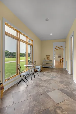 a living room with couches a table and chairs with wooden floor