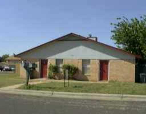 a backyard of a house with table and chairs under an umbrella