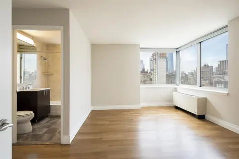 a view of an empty room with glass door and a window