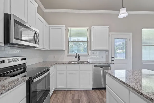 a kitchen with stainless steel appliances granite countertop a sink and stove top oven