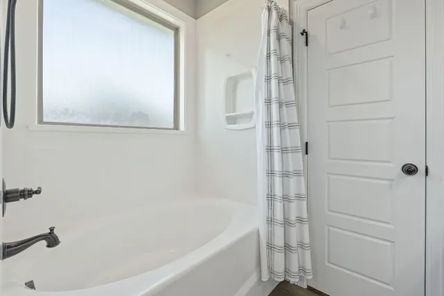 a bathroom with a tub and shower