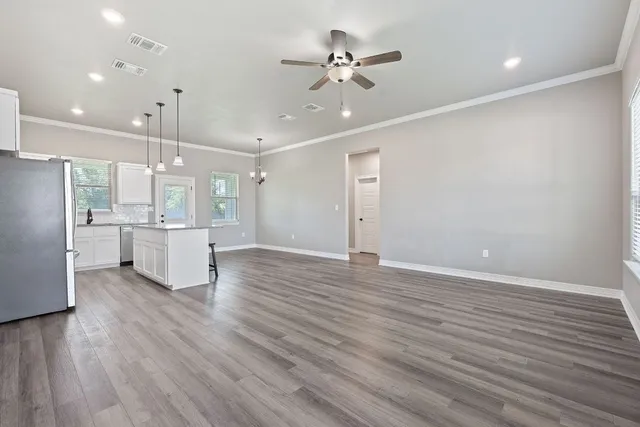 wooden floor in an empty room with a kitchen