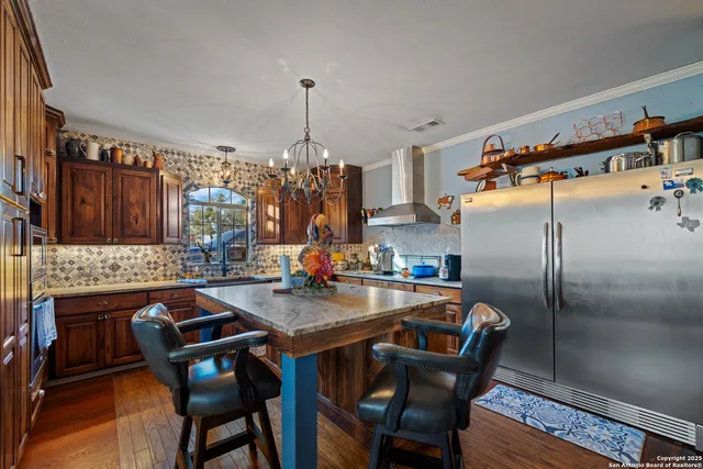 a kitchen with stainless steel appliances granite countertop a kitchen island a stove and a wooden cabinets