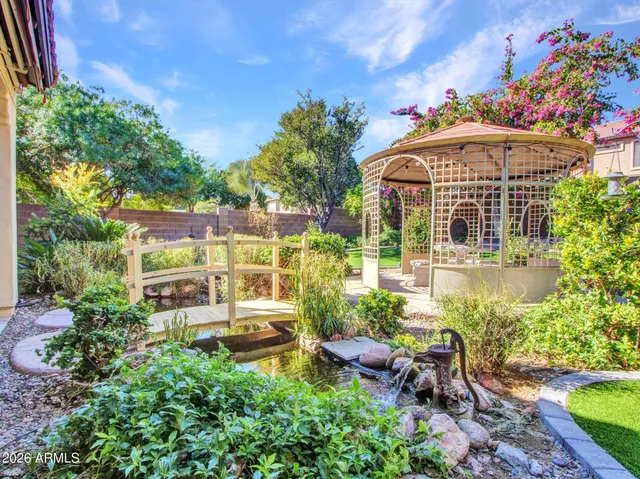 a kitchen with stainless steel appliances granite countertop a refrigerator a stove a sink a dining table and chairs