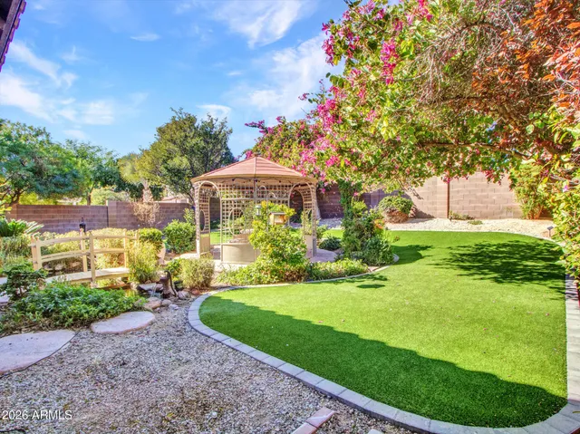 a kitchen with stainless steel appliances granite countertop a stove top oven a sink dishwasher a dining table and chairs with wooden cabinets