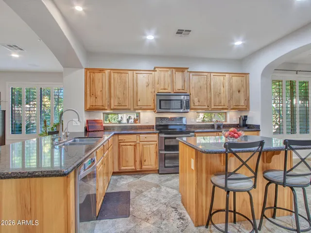 a bathroom with a granite countertop sink a mirror and a potted plant