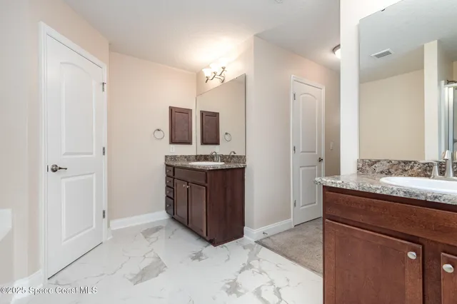 a spacious bathroom with a granite countertop sink and a mirror