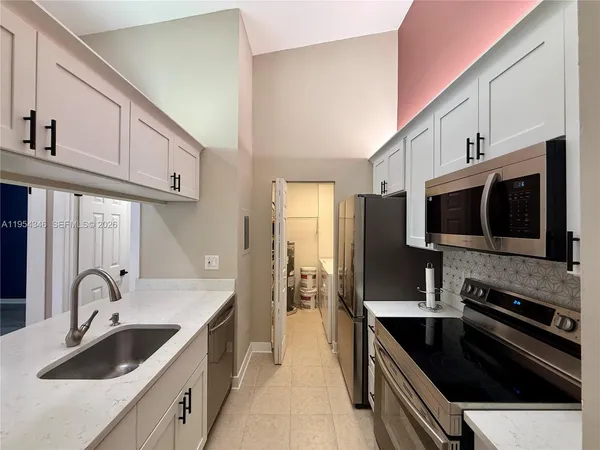 a kitchen with stainless steel appliances a stove sink and microwave