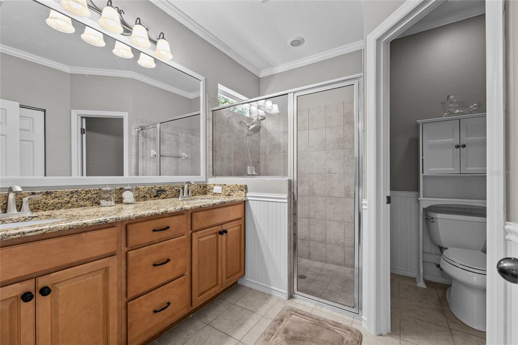 8251 Southwest 78th Lane Gainesville, FL 32608 - Photo 18 of 29 a bathroom with a granite countertop sink a toilet and shower