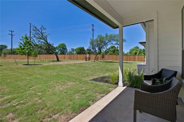 a view of a chair and table in the back yard of the house