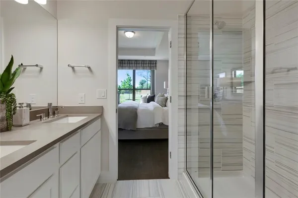 a en suite bathroom with a granite countertop sink and shower