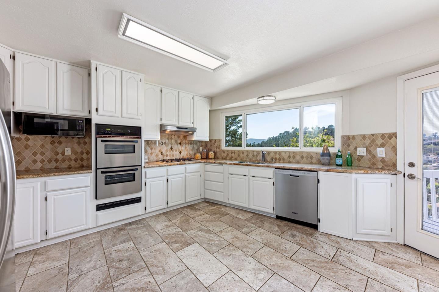 1063 Glacier Avenue Pacifica, CA 94044 - Photo 16 of 63 a kitchen with granite countertop a refrigerator sink and cabinets