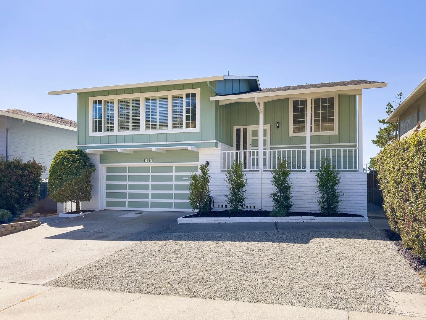 1063 Glacier Avenue Pacifica, CA 94044 - Photo 2 of 63 a front view of a house with a yard and potted plants