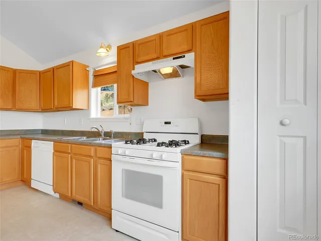 a kitchen with stainless steel appliances granite countertop a sink a stove cabinets and living room view