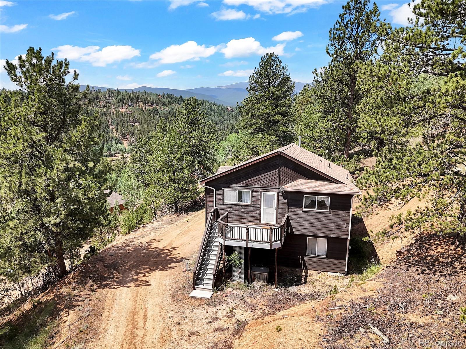 367 Moore Street Bailey, CO 80421 - Photo 4 of 32 a front view of a house with a yard and balcony