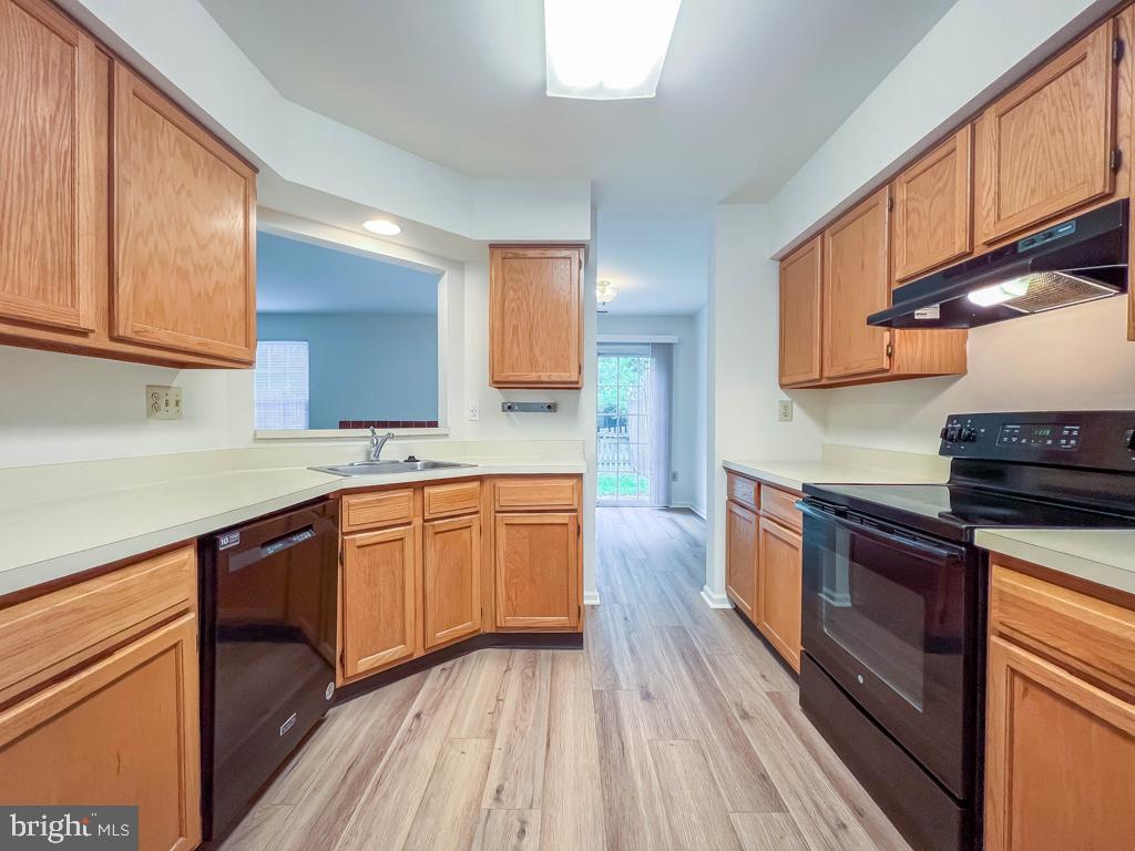 14 Carousel Circle Doylestown, PA 18901 - Photo 12 of 35 a kitchen with stainless steel appliances granite countertop wooden cabinets a stove top oven a sink and dishwasher with wooden floor